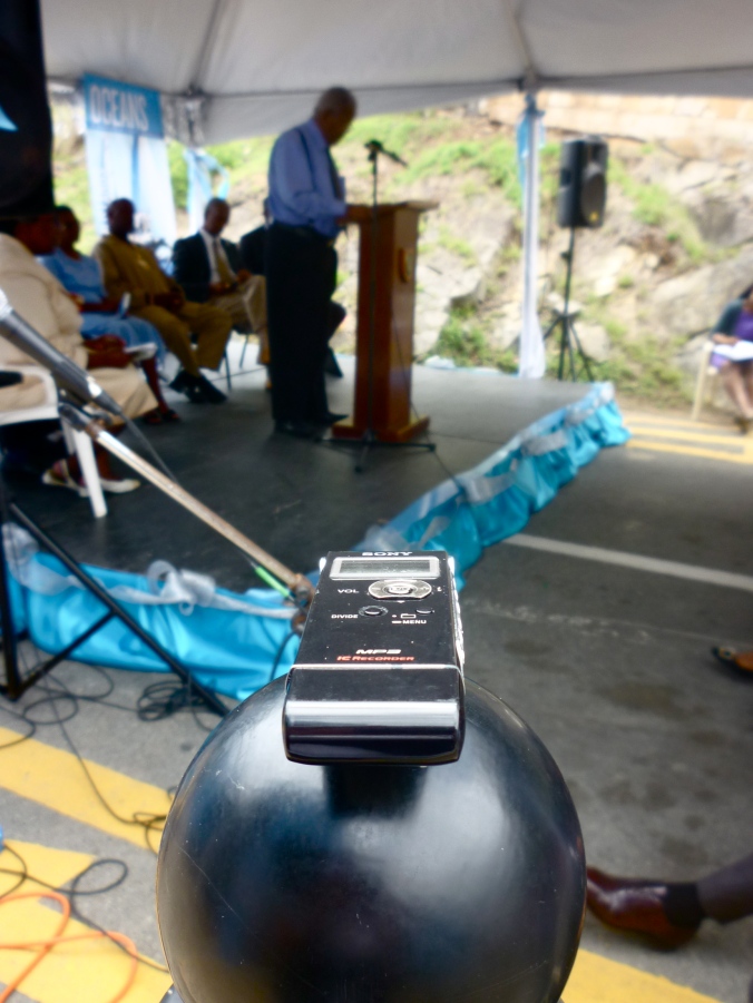 Audio recorder securely fastened to a round surface with double-sided tape, press conference in the background